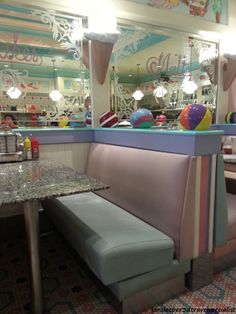 the inside of a restaurant with booths and tables in front of mirrors on the wall