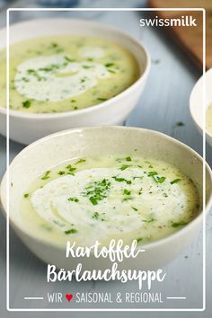 two white bowls filled with soup on top of a table