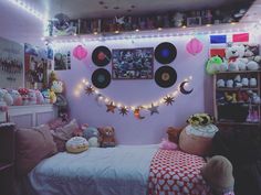 a bedroom decorated in pink and white with lots of stuffed animals