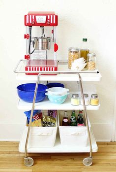 a red and white coffee maker sitting on top of a cart