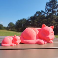 two pink cat figurines sitting on top of a table