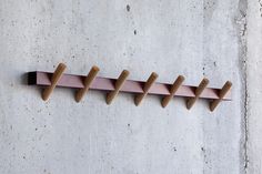 three wooden pegs are attached to the side of a wall