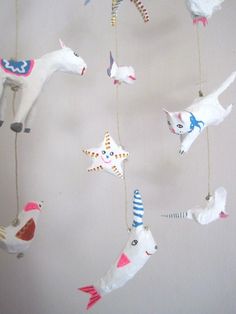 a mobile with animals and birds hanging from it's sides in the shape of stars