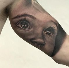 a man's arm with an eye tattoo on it