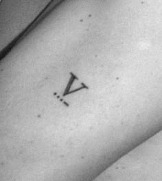 a black and white photo of a woman's arm with a small triangle tattoo on it