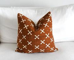 a brown and white pillow sitting on top of a bed