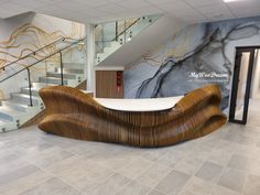 a large wooden bench sitting in the middle of a lobby next to stairs and glass railings