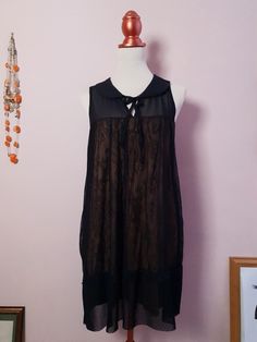 "This black lace baby doll dress features a charming peter pan collar and front ribbon tie for a timeless, feminine look. The golden beige underlay gives a beautiful contrast to the vintage black lace overlay, creating an eye-catching classic.  Era - Late 90s Fit - 35\" Length / 38\" Bust / Free waist Size 12 UK Fabric - Polyester/lace Care - Recommend machine wash cool or hand wash Excellent condition" 90s Fits, Baby Doll Dress, Feminine Look, Babydoll Dress, Lace Overlay, Dress Clothes For Women, Baby Doll, Doll Dress, Vintage Black