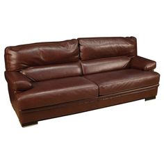 a brown leather couch sitting on top of a white floor