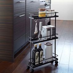 a kitchen cart with wine bottles and other items on it