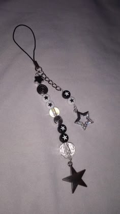 a black and white beaded necklace with star charms hanging from it's side