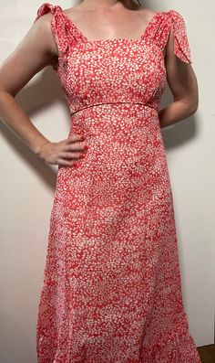 This floral maxi dress is the stuff of dreams! It is Union Made and from the 1970's, made predominantly of cotton and polyester. It's a gorgeous dress and perfect for spring and summer! It is a coral pink color with a white floral pattern on it. It is closest to a modern day size 2/4, but here are the exact measurements taken lying flat and doubled: Shoulders: 15 inches Chest: 28 inches Waist: 24 inches Hips: 30 inches Shoulders to Hem: 50 inches This dress has an inner lining too, so it keeps i Spring Sundress Maxi Dress, Retro A-line Maxi Dress, Spring Orange Lined Maxi Dress, Spring A-line Orange Maxi Dress, Spring Pink A-line Maxi Dress, Red Retro Maxi Dress For Summer, Retro Orange Maxi Dress For Summer, Orange Retro Maxi Dress For Summer, Orange Retro Summer Maxi Dress