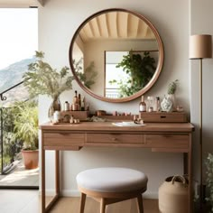 a vanity with a mirror, stool and potted plants on it in front of a balcony