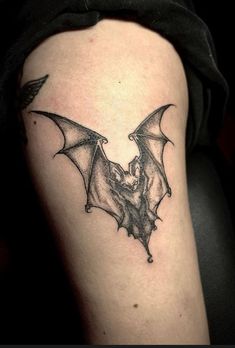 a black and white photo of a bat tattoo