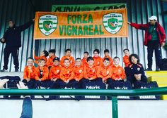 a group of young people sitting on top of a soccer field next to each other