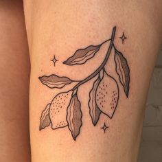 a tattoo on the leg of a woman with leaves and stars around her legs,