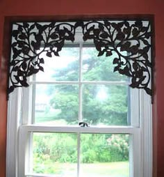 the window is decorated with black leaves and has a white valance on it's side