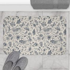 a pair of slippers sitting on top of a bathroom floor next to a rug