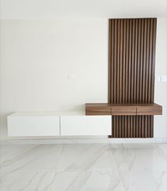 an empty room with white walls and wooden accents on the wall, along with marble flooring