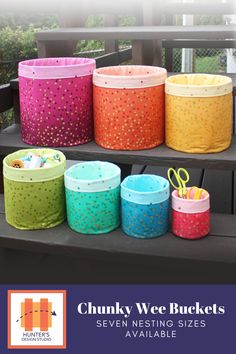 several colorful baskets sitting on top of a wooden bench with the words chunk wee buckets seven nesting sizes available