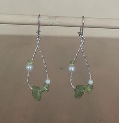 These earrings feature three different sizes and shapes of peridot stones, as well as little glass and plastic pearls. The hooks are silver, and the wire used to create the earrings is silver with a copper core. Two backpieces will be provided along the earrings. Two backpieces will be provided along the earrings. Fairy Treasure, Peridot Stone, Stone Earrings, Jewelry Earrings Dangle, Dangle Drop Earrings, Dangle Earrings, Germany, Jewelry Earrings, Copper