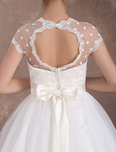 the back of a woman's wedding dress with white polka dots and bows on it