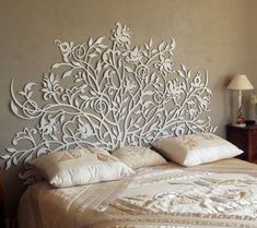 a large white headboard sitting on top of a bed next to a night stand