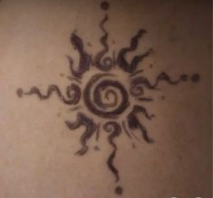 an artistic tattoo design on the back of a woman's shoulder