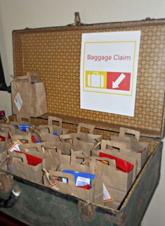 an open suitcase filled with paper bags and other items next to a sign that says baggage claim