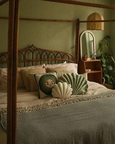 a bedroom with a bed, dresser and mirror in the corner next to a potted plant