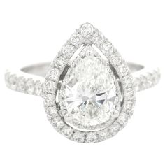 a pear shaped diamond ring set in white gold with diamonds around the band and shoulders