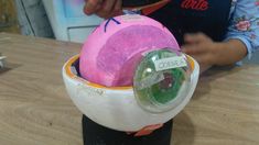 a child is playing with an egg in a container on top of a wooden table