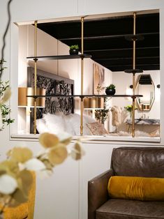 a living room filled with furniture next to a window covered in plants and windowsills