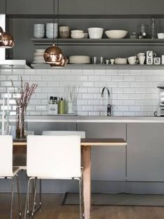 the kitchen is clean and ready to be used for dinner or lunchtime, with stainless steel shelving above the sink