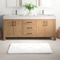 a bathroom vanity with two mirrors above it and a rug on the floor in front of it