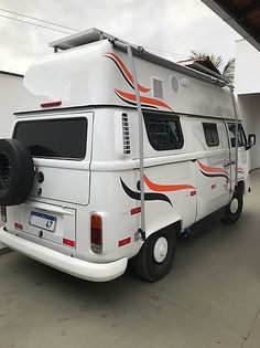 an rv parked in a garage next to a building with a palm tree on top