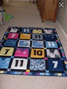 there is a quilt on the floor that has numbers and t - shirts all over it