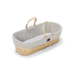 a baby bassinet that is made out of wicker and has two handles