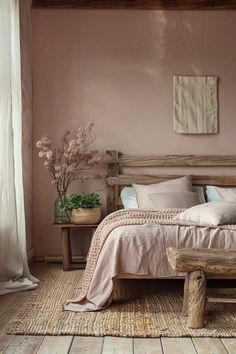 a bed sitting in a bedroom next to a window with white curtains and pink walls