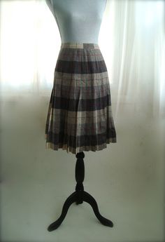 "This is a classic wool plaid, pleated secretary, or career skirt. This high waisted skirt features a back zipper and button closure and a lovely plaid in shades of grey with red. This skirt is in excellent condition. Skirt is a size medium, please see measurements below.  14\" across waist, seam to seam hips free 25\" length, waist to hem" Elegant Fitted Plaid Skirt, Classic Plaid Skirt For Fall, Classic Pleated Plaid Skirt, Fall Fitted Skirt With Box Pleat, Fitted Box Pleat Skirt For Fall, Plaid Pleated Skirt For Workwear In Fall, Plaid Full Skirt For Work, Vintage Fitted Flared Pleated Skirt, Fitted Full Skirt In Plaid