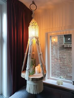 a lamp hanging from the ceiling next to a window