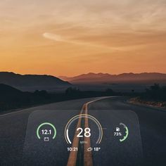 an image of a speedometer on the road at sunset or sunrise with mountains in the background