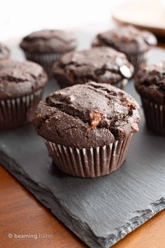 chocolate muffins sitting on top of a gray napkin