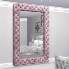 a pink mirror sitting on the side of a wall next to a white bed in a room