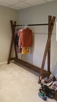 an empty room with shoes and clothing hanging on clothes racks in front of the closet door