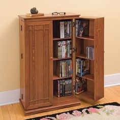 a wooden cabinet with several dvd's and video games in it on the floor