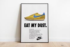 a poster with the words eat my dust written in blue and yellow on it, next to a pair of shoes