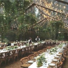 an outdoor dining area with tables, chairs and lights strung from the ceiling over them