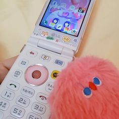 a pink stuffed animal next to a cell phone