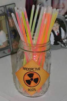 a jar filled with plastic straws sitting on top of a table